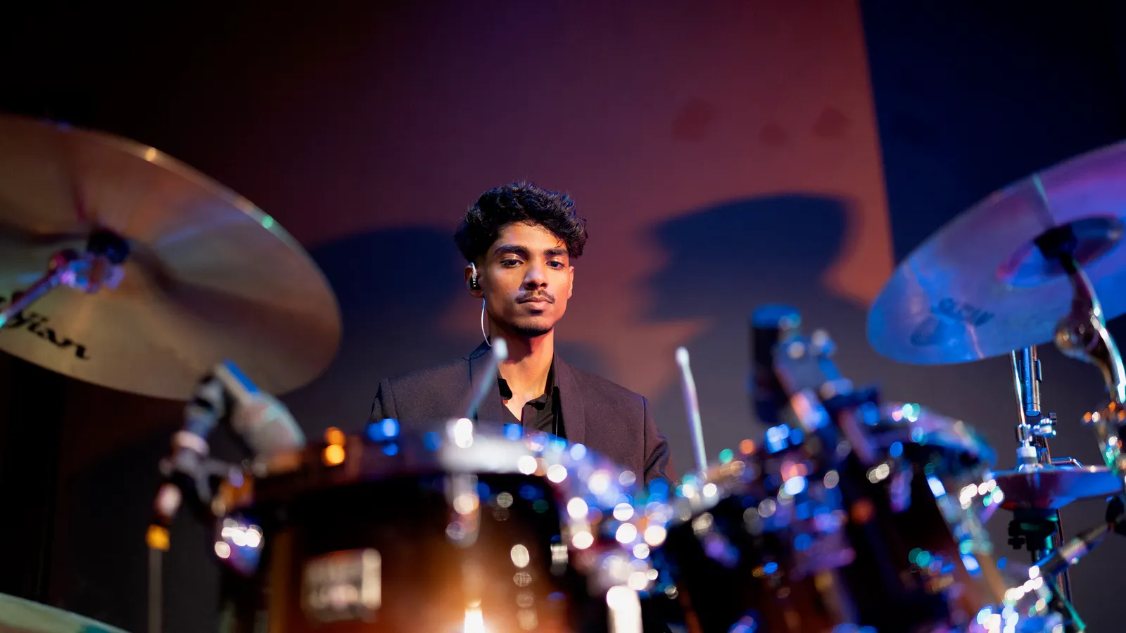 Behind the drum kit under stage lights