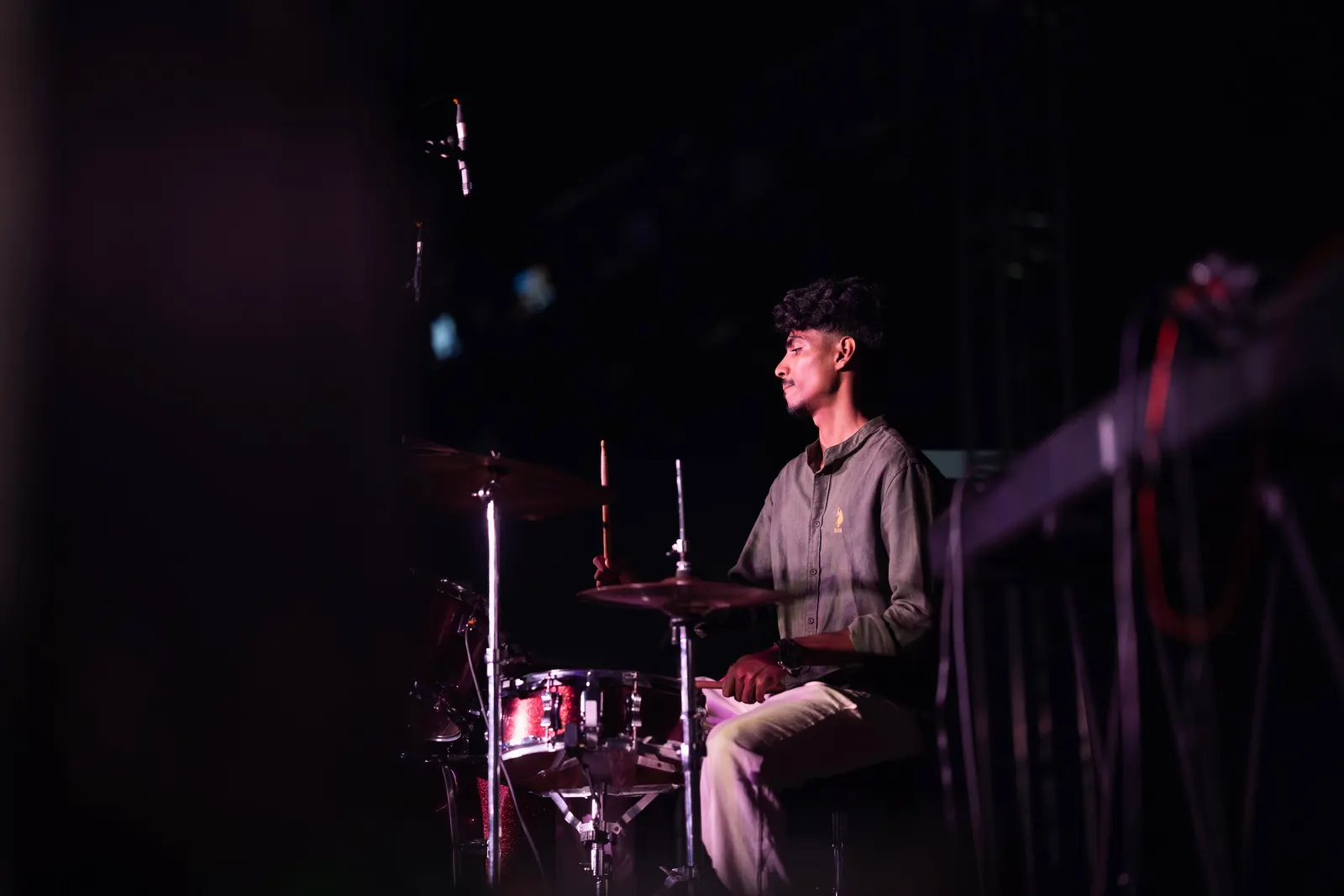 Ephraim playing drums on stage in low light