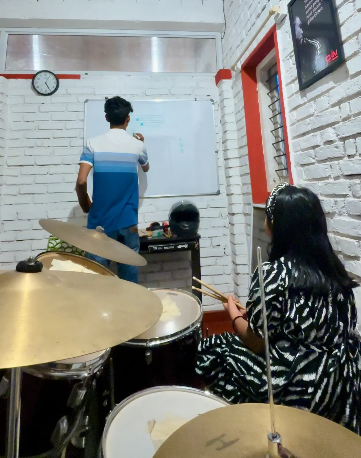 Writing notation on the whiteboard during a drum lesson