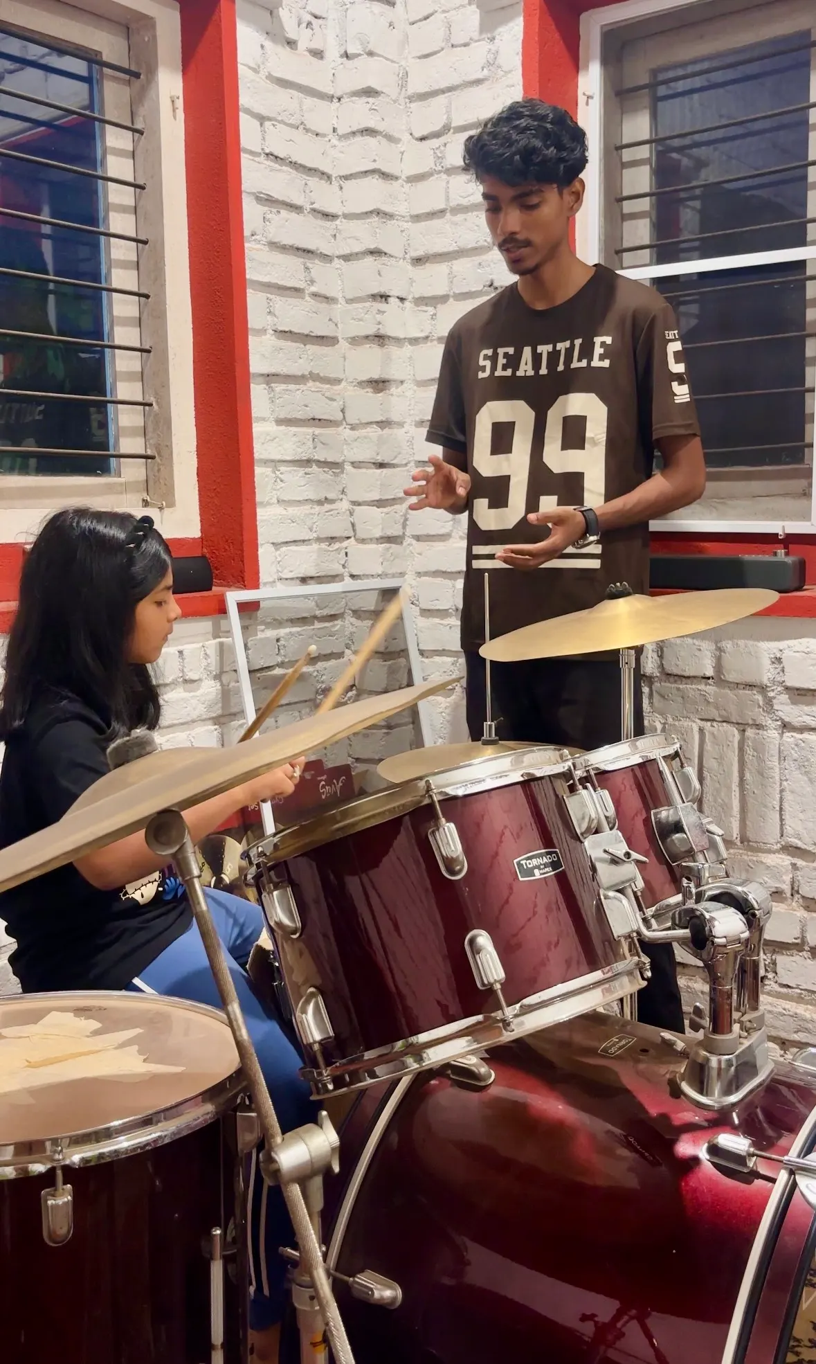 Coaching a young student through a beat at the kit